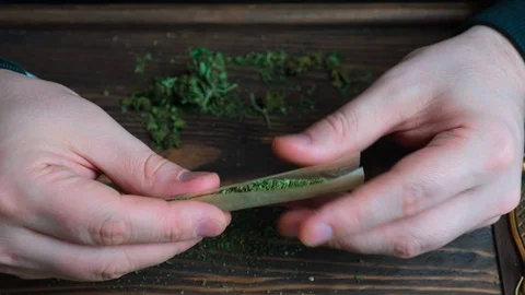 Man rolling cannabis joint Stock Footage 128070789