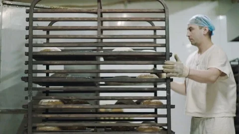 Man is rolling a cart with bread Stock Footage 76886605