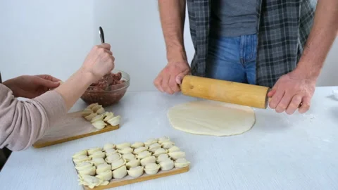 Man is rolling dough for dumpings using rolling pin on table, hands closeup. Stock Footage 152776065