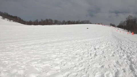 A man is rolling down a snow slide at high speed. Winter entertainment Stock Footage 264489369