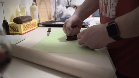 A man rolls dough with a rolling pin for gingerbread. Christmas sweets 4K video Stock Footage 128623840