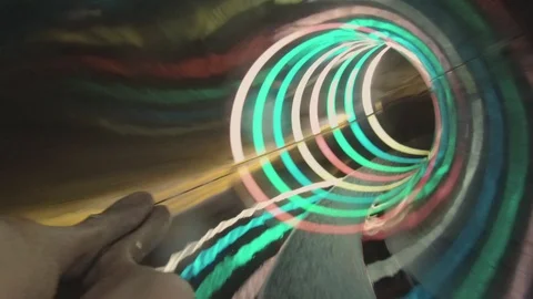 A man rolls in a multi-colored tube on a water slide. Water park. Stock Footage 120184500