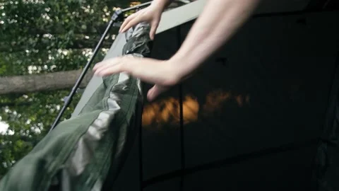 Man rolls open tent door and locks it close up. Sunset. vertical video Stockbeeldmateriaal 207431327