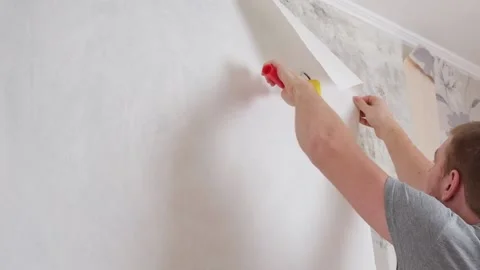 A Man Applies Wallpaper Glue With Brush For Wallpapering Repair Of
