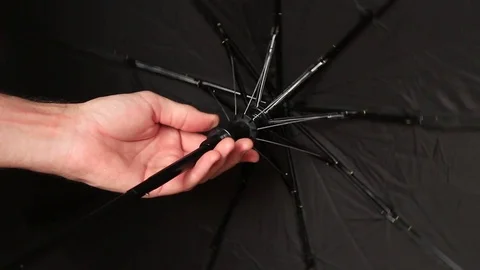 Man rolls umbrella in his hands 動画素材 70743630