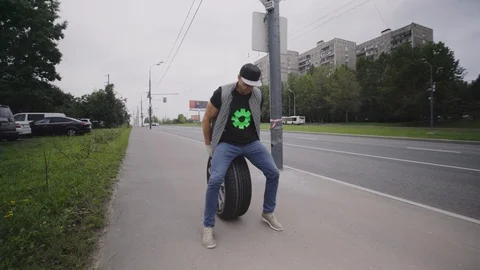 A man rolls a wheel on the road. Stock Footage 93026425