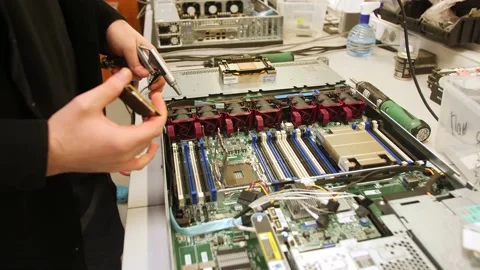 A man in a room for assembling server and computer equipment, adds parts, compon Stock-Footage 208296939
