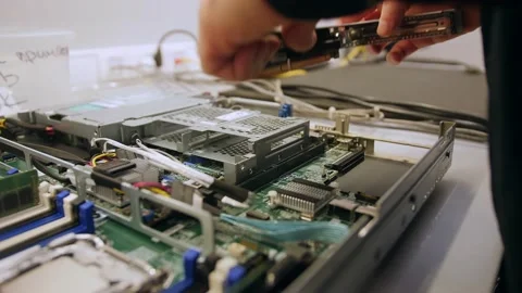 A man in a room for assembling server and computer equipment, adds parts, compon Stock-Footage 208297069