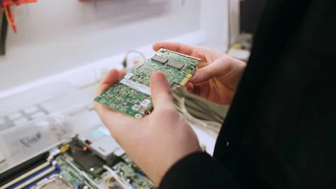 A man in a room for assembling server and computer equipment, adds parts, compon Stock-Footage 208297074