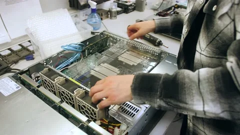 A man in a room for assembling server and computer equipment, adds parts, compon Stock-Footage 208297317