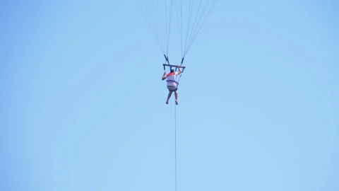 Man on rope flies over the red sea on a parachute over a boat Stock Footage 106659984