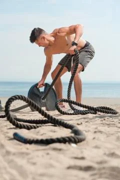 Man with ropes on a beach in a daylight Stock Photos