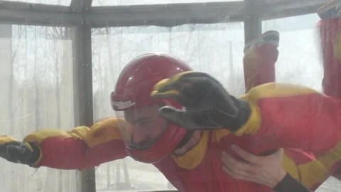 Man rotates in the air during a flight in wind channel. free fall training Stock Footage 91744294