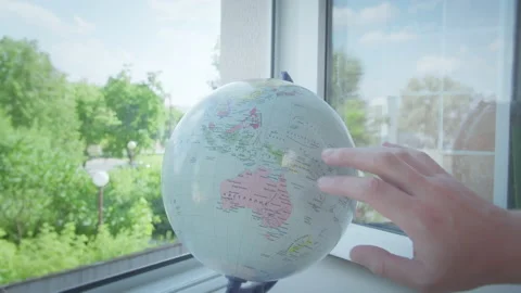 Man rotates the globe, which stands on the windowsill by the open window 스톡 동영상 166647198
