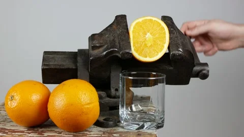 Man rotates handle of clamping vise and force juice out of orange Vidéo 147603036