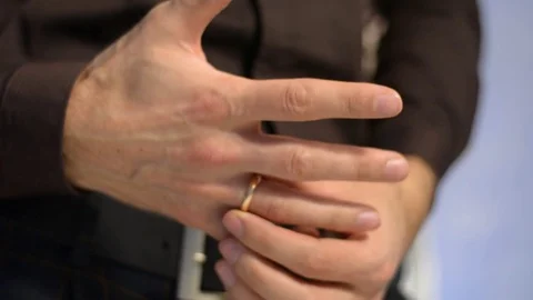 A man rotates a wedding ring on his finger. Young groom 스톡 동영상 123363601