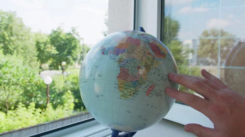 Man Rotating Globe by Open Window Stock Footage 329923343