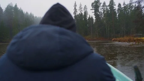 Man in a rowboat on a lake while it's raining Video stock 83241253