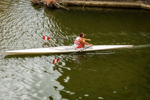 Man rower in a single scull training on the Arno River - Florence Italy Stock Photos