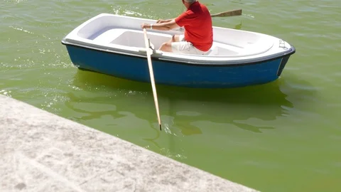 Man rowing in a boat in a pond Video stock 116550379