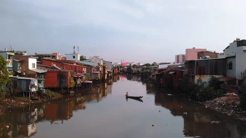 Man rowing a boat in a slum area of Saigon Stock Footage