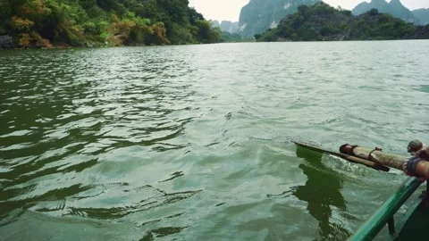 Man Rowing Boat Through Karst Mountains in Ninh Binh Vietnam Stock Footage 340017808