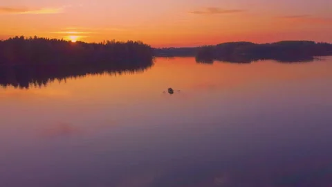 A man rowing on a calm lake at sunset. Aerial footage. Stock Footage 212698277
