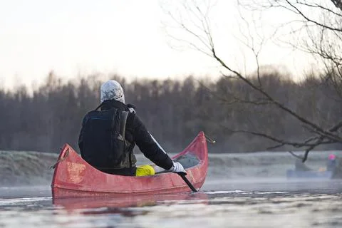 Man rowing a canoe in early spring in the early morning. lifestyle. Morning Stock Photos