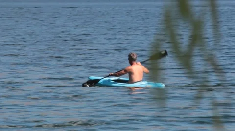 Man Rowing in Kayak Across Pristine Blue Waters Stock Footage 40301475