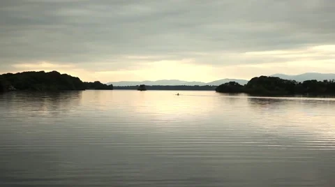 Man rowing in lake with cloudy sky Stock Footage 45125139