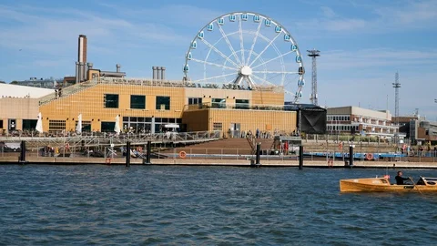 Man rowing an ocean rowing boat in front of Helsinki Sky Wheel Video stock 117370825