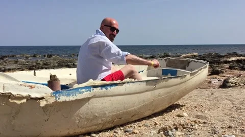 Man rowing an old ship on the beach Stock Footage 62833600