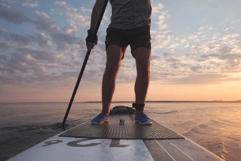A man is rowing on a stand-up board. Far from the coast. Stock Photos