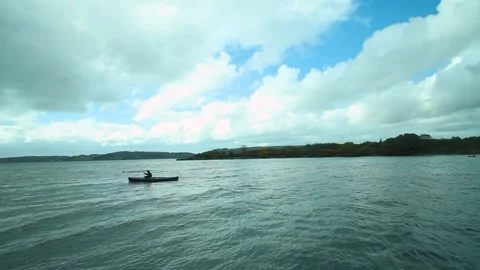A man rowing in the water in a canoe Stock Footage 236708497