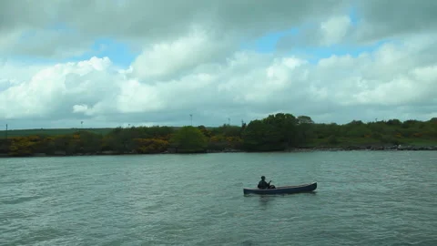 A man rows against the tide in a canoe Stock Footage 236708467
