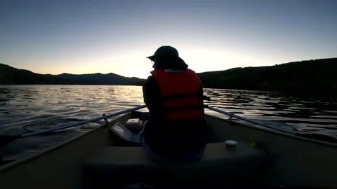 Man rows boat at dusk Stock Footage 155296749