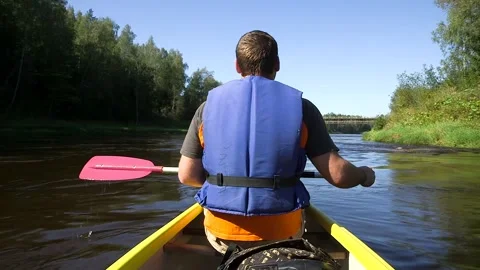 Man Rows a Canoe on the River, Approaches the Bridge Stock Footage 285144213