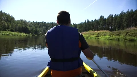 Man Rows a Canoe on the River Stock Footage 285144199
