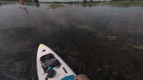 A man rows an oar in first person, sits in a kayak, surrounded by forest and blu Stock Footage 278508409
