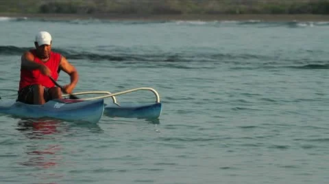 A man rows an outrigger canoe fast. Stock Footage 9323818