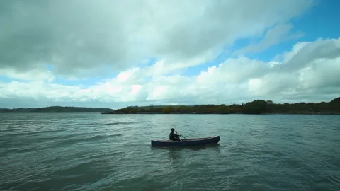 A man rows past in a canoe Stock Footage 236708599