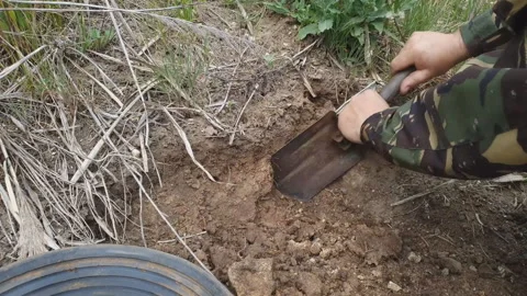 man in rubber boots digs a shovel pit in... | Stock Video | Pond5