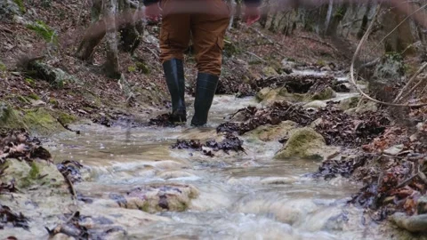 Man rubber boots river. Washes boots in cold water. Stock Footage 220598146
