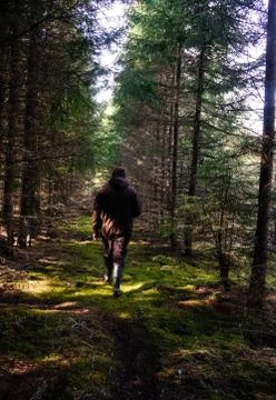A man in rubber boots in the spring forest Stock Photos
