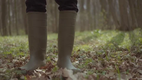A man in rubber boots walks through the forest. Footsteps in boots on a path Stock Footage 305407220