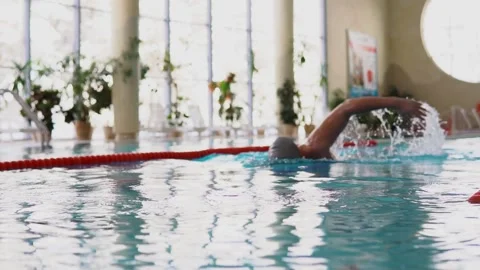 A man in a rubber cap swims in the breaststroke pool Stock Footage 145756153