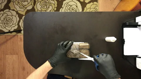 A man with rubber gloves. Cuts the package of the received parcel with scisso Stock Footage 144832953