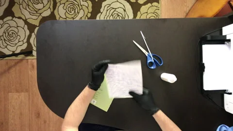 A man with rubber gloves. Examines the greeting card and the attached letter. Stock Footage 144833331