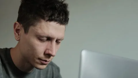Man rubbing eyes while working on laptop. Tired eyes from long screen time. Free Stock Footage 308076297