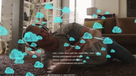 Man on rug tapping phone, generating blue cloud icons, code moving over him Stock Footage 333704351